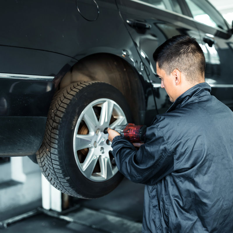 mechanic putting new tires on car