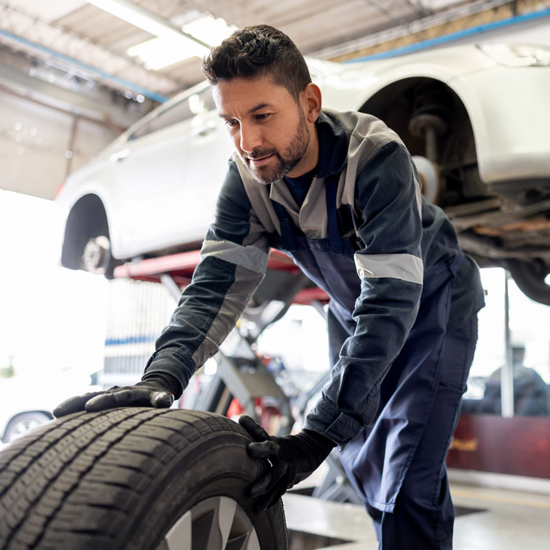 mechanic replacing tires on car