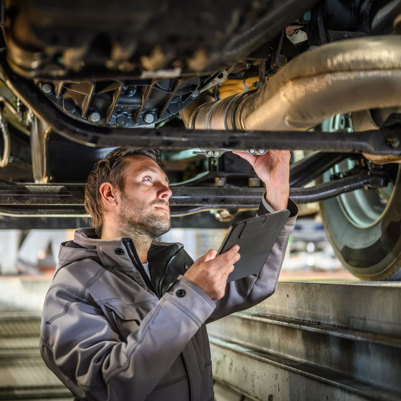 mechanic inspecting car underbody